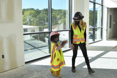 a construction worker tours a child around a construction site