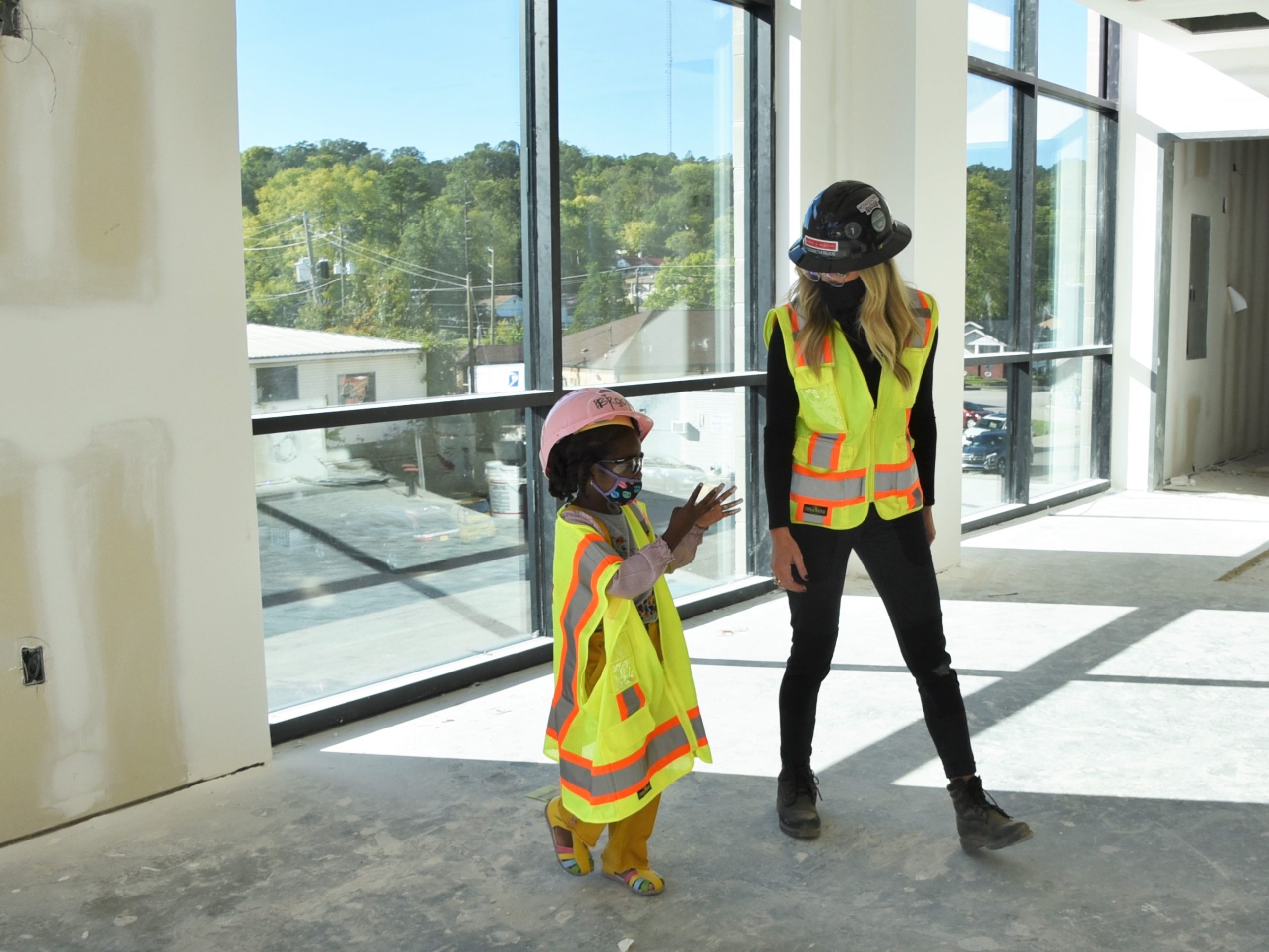 a construction worker tours a child around a construction site