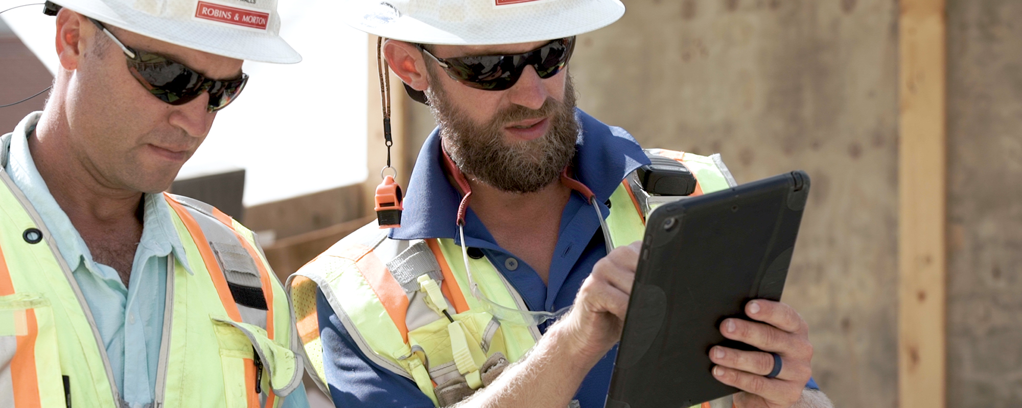 construction workers looking at drawings on an iPad