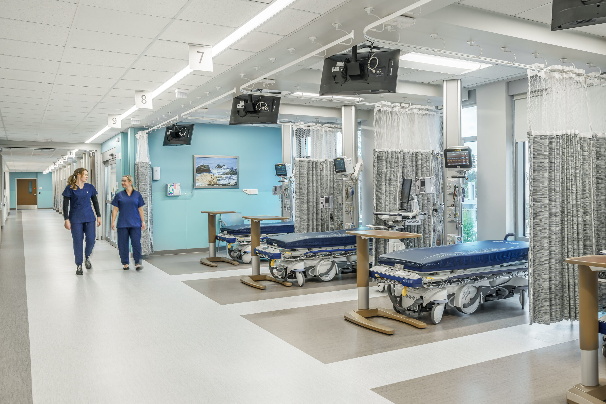 An image of multiple hospital beds with curtains in between
