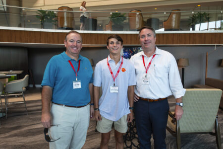 three people posing at an event