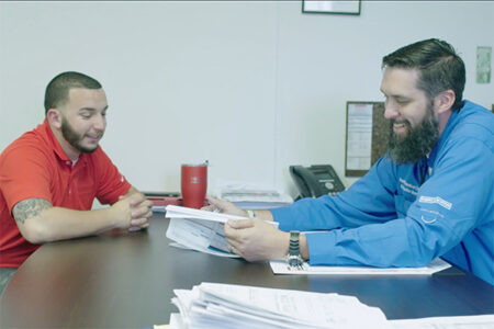 men discussing paperwork