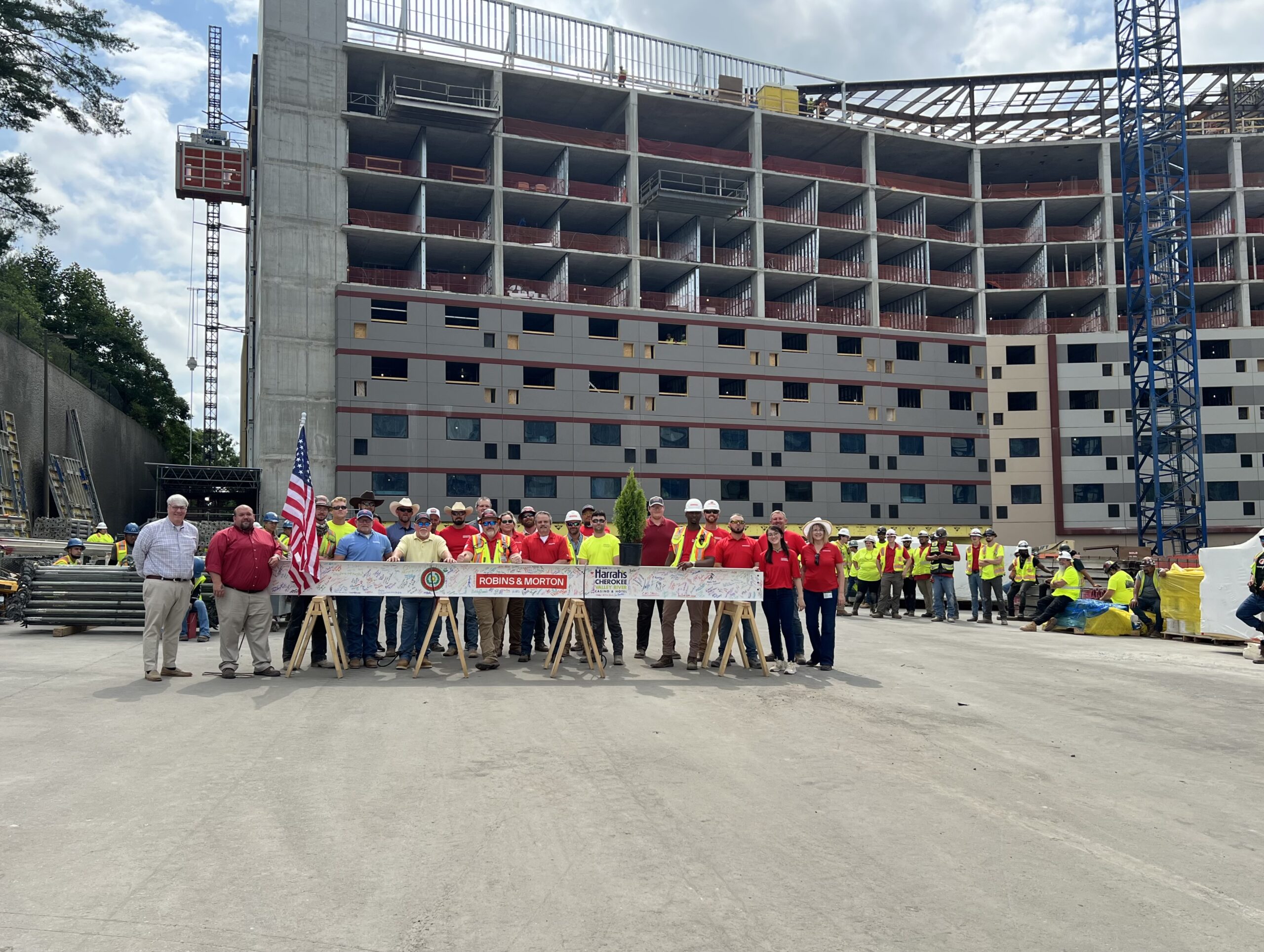 group of people posing in front of a in-progress hotel