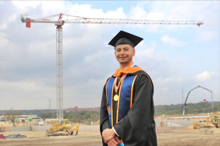 a college graduate standing on a construction site