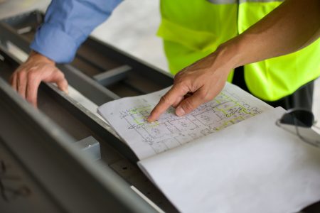 open plan book with fingers pointing to details