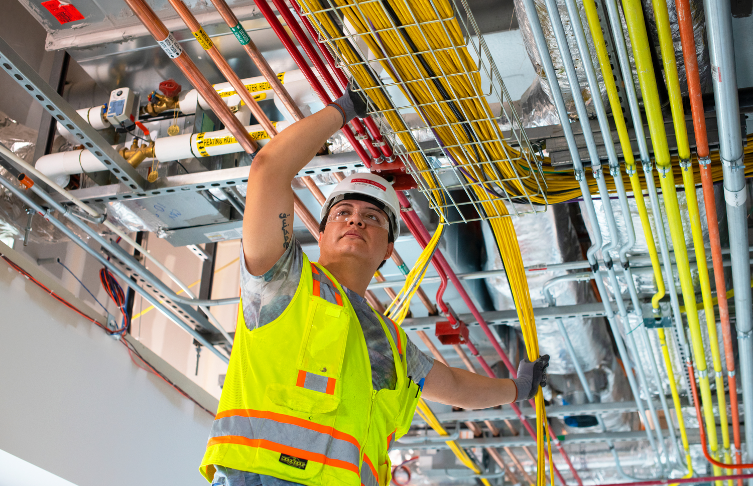 man installing low voltage wiring overhead