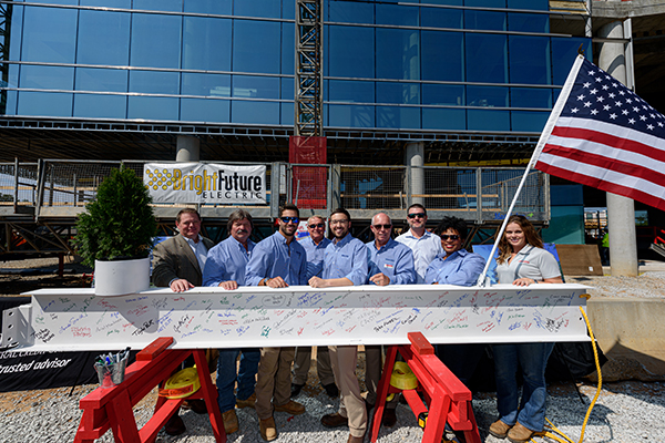 construction workers stand with beam