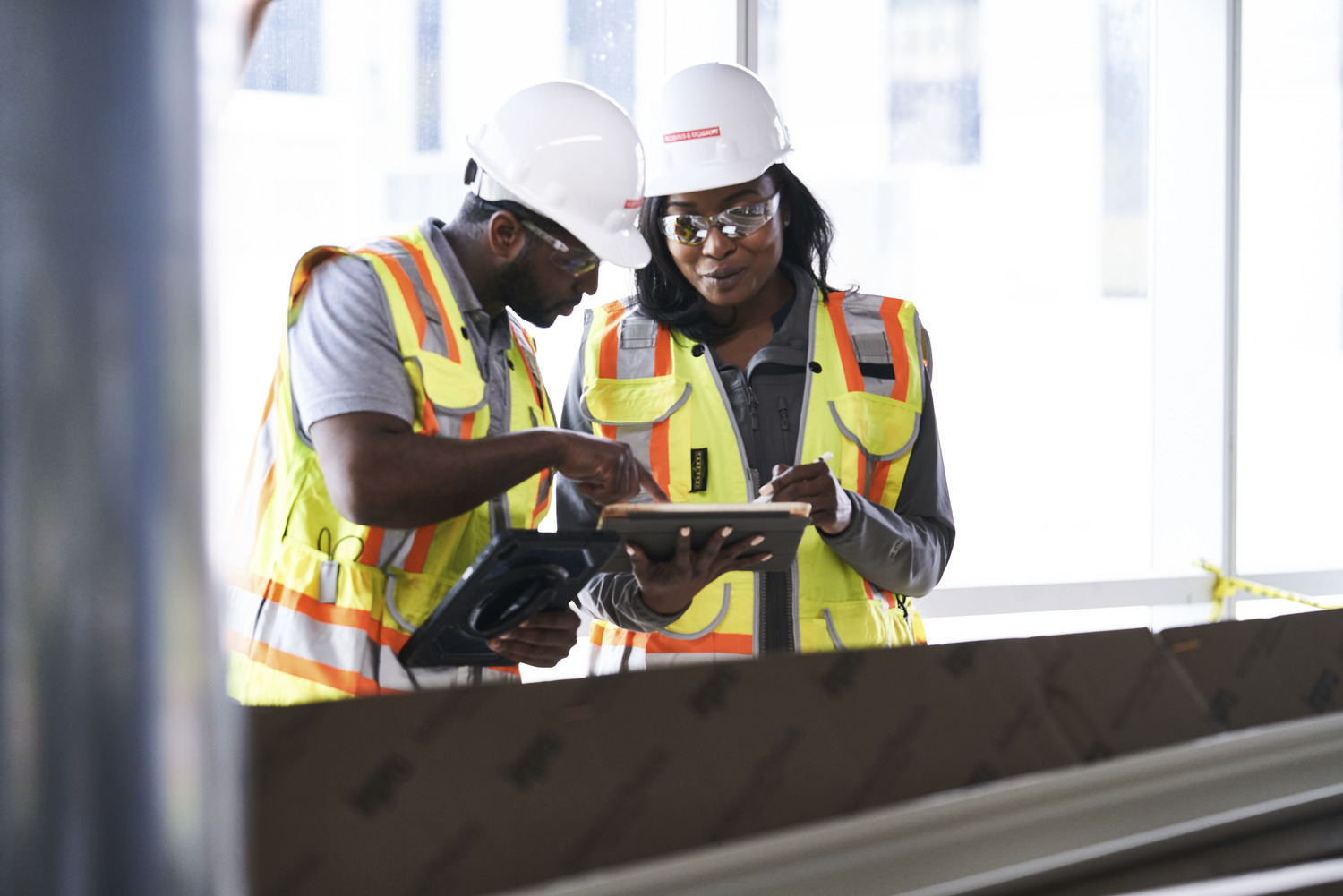 two people reviewing building plans on an ipad